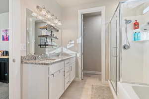 Full bathroom with double vanity and a stall shower