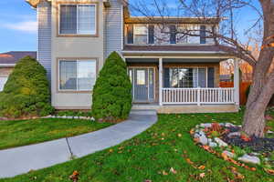 Traditional-style house featuring a porch and a front yard