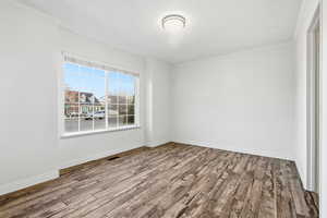 Spare room featuring crown molding and wood finished floors