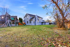 Rear view of property with a fenced backyard and a playground