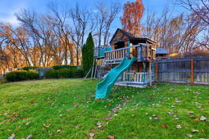 View of playground with a fenced backyard