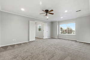 Empty room with crown molding, a ceiling fan, recessed lighting, and light colored carpet