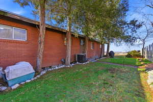 View of home's exterior with a central air condition unit and brick siding