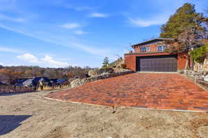 View of front of home featuring driveway, brick siding, and an attached garage