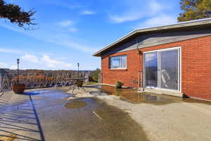 View of property exterior with brick siding and a patio area