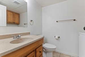 Bathroom with vanity, light tile patterned floors, and washer / dryer