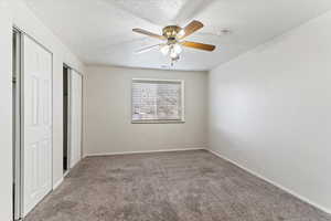 Unfurnished bedroom featuring a ceiling fan, carpet flooring, and a textured ceiling