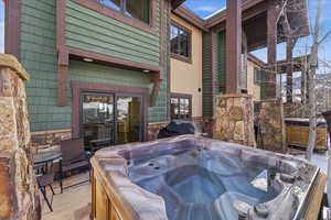 View of patio with a hot tub and a grill