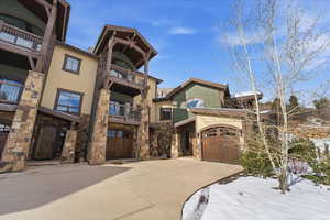 View of property featuring concrete driveway and a garage