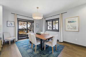 Dining room with dark wood-type flooring and baseboards