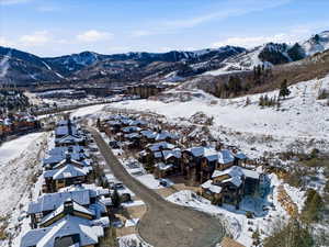 Snowy aerial view featuring a mountain view and a residential view