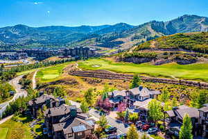 Aerial perspective of suburban area featuring a mountainous background and a local golf course
