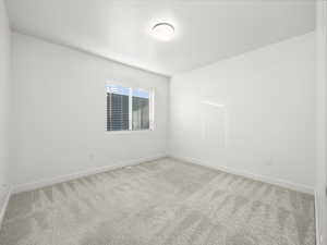 Empty room featuring carpet flooring and baseboards