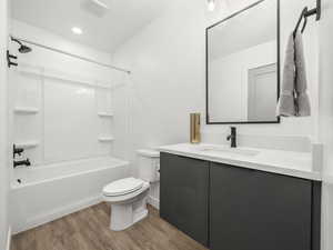 Full bath with vanity, shower / tub combination, and light wood-style floors