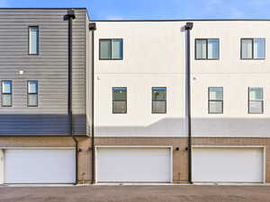 Rear view of property with brick siding and a garage