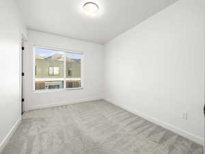 Unfurnished room featuring light colored carpet and baseboards