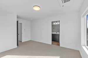 Unfurnished bedroom with light colored carpet, ensuite bath, and cooling unit