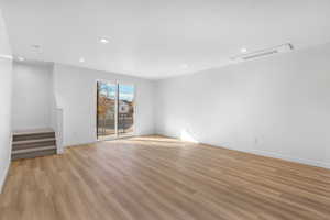 Spare room featuring recessed lighting, light wood-style floors, and stairway