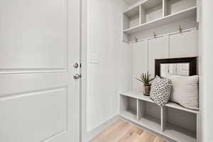 Mudroom with light wood-style floors and baseboards