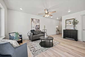 Living area with a ceiling fan, recessed lighting, and light wood-type flooring