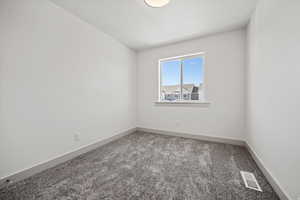 Carpeted spare room with baseboards