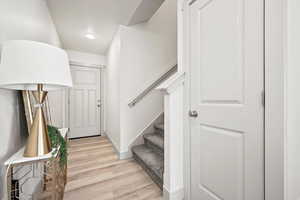 Stairway with wood finished floors and baseboards