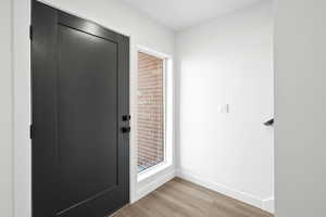 Entryway featuring baseboards and wood finished floors