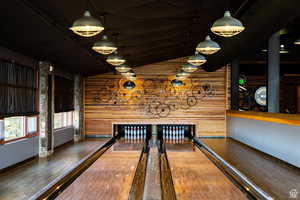 Playroom with a bowling alley, lofted ceiling, and wood walls