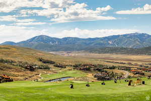 View of mountain background featuring a large body of water and a local golf course