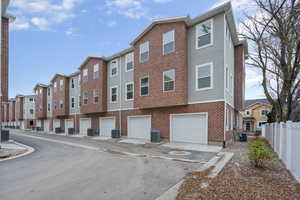 View of building exterior with an attached garage and driveway