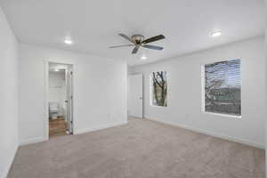 Unfurnished bedroom with light carpet, a ceiling fan, recessed lighting, and ensuite bathroom