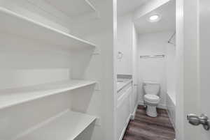 Full bathroom featuring vanity, dark wood-style flooring, and bathtub / shower combination