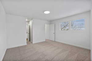 Unfurnished bedroom with carpet flooring and baseboards