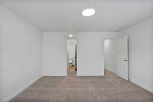 Unfurnished bedroom featuring light carpet and ensuite bath