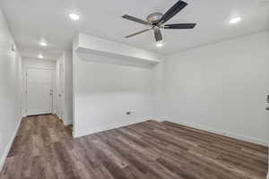 Spare room with dark wood-style flooring, a ceiling fan, and recessed lighting