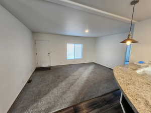 Unfurnished living room featuring dark colored carpet