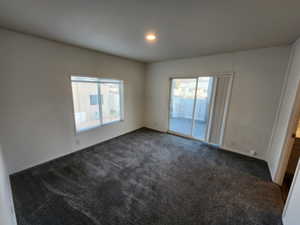 Unfurnished room with dark colored carpet and recessed lighting
