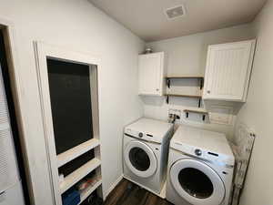 Laundry area featuring independent washer and dryer, dark wood-style floors, cabinet space, and a heating unit