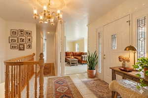 Entrance foyer with hanging lights and light tile patterned floors