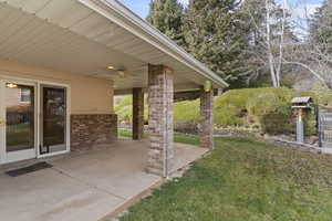 View of grassy yard featuring a patio area and ceiling fan