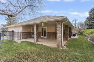 Rear view of property with stucco siding, a patio area, brick siding, and ceiling fan