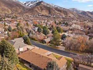Aerial view of property and surrounding area with a mountain backdrop and nearby suburban area