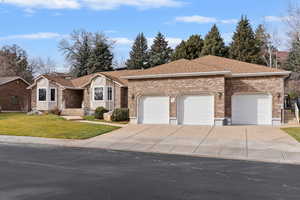 Ranch-style house with a front yard, driveway, a garage, brick siding, and a shingled roof