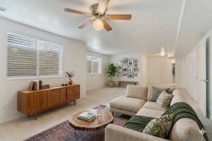 Carpeted living room featuring ceiling fan