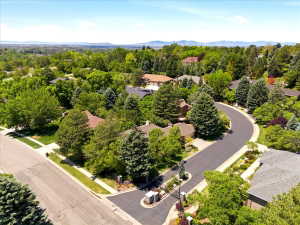 Curved asphalt street with concrete sidewalks bordered by manicured landscaping
