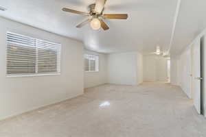 Empty room featuring carpet floors and a ceiling fan