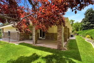 Expansive rear patio area featuring a concrete surface and brick-faced columns