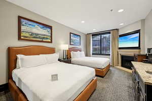 Bedroom featuring a fireplace with flush hearth, recessed lighting, and dark carpet