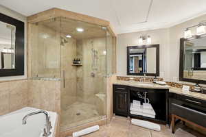 Full bathroom featuring vanity, a stall shower, and a bath