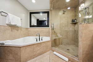 Full bathroom featuring a garden tub, a shower stall, and recessed lighting